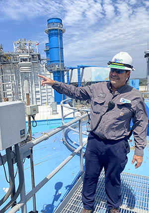 A technician points to a Weather Station installed at the site.