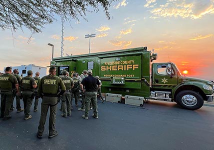 Riverside County Sheriff Deputies gather around a Mobile Command Post
