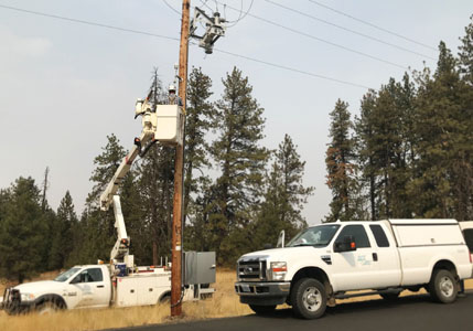 workers installing weather station on power pole
